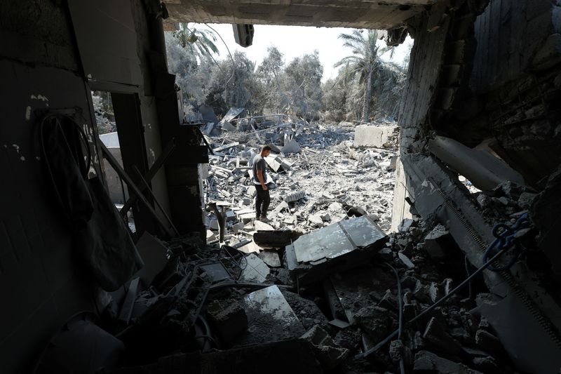 © Reuters. A Palestinian inspects a house destroyed in an Israeli strike, amid the Israel-Hamas conflict, in Nusairat refuge camp, in the central Gaza Strip, July 9, 2024. REUTERS/Ramadan Abed