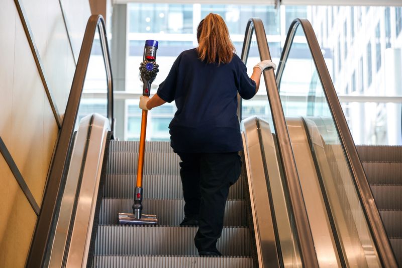&copy; Reuters. File photo: A cleaner holds a Dyson vacuum cleaner whilst traveling on an escalator in an office building in London, Britain, September 27, 2022.   REUTERS/Kevin Coombs/File photo
