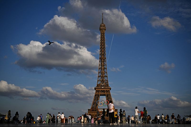 &copy; Reuters. FILE PHOTO: People enjoy the evening as the Olympic rings are displayed on the Eiffel Tower, ahead of the Paris 2024 Olympic games in Paris, France, June 22, 2024. REUTERS/Dylan Martinez/File Photo