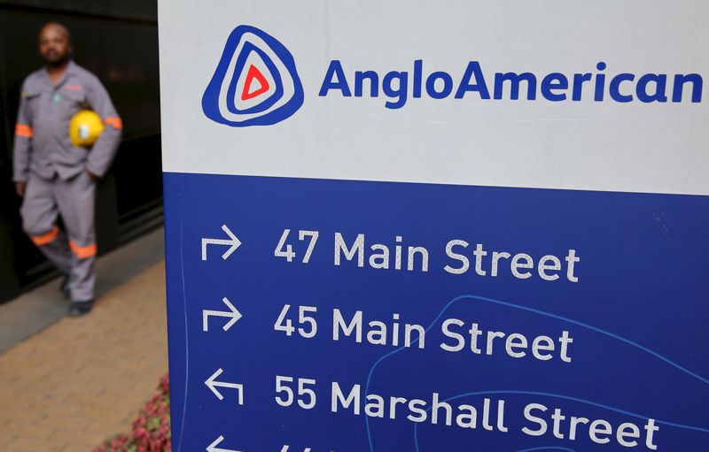 © Reuters. File photo: A worker walks past a board outside Anglo American offices in Johannesburg, August 21, 2015. REUTERS/Siphiwe Sibeko/File photo