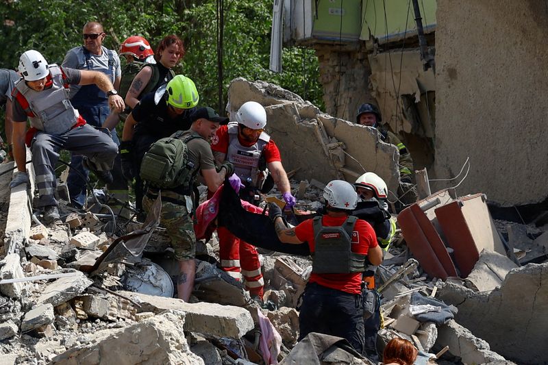 &copy; Reuters. FILE PHOTO: Rescuers and paramedics carry a body of a child found at a site an apartment building heavily damaged during a Russian missile strike, amid Russia's attack on Ukraine, in Kyiv, Ukraine July 8, 2024. REUTERS/Valentyn Ogirenko/File Photo