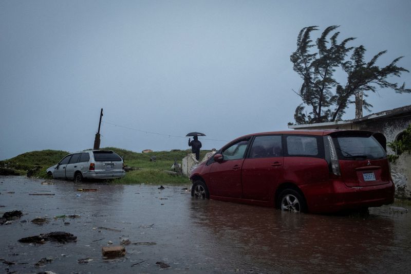 © Reuters. FILE PHOTO: A man looks at breaking waves in the Caribbean Terrace neighborhood as Hurricane Beryl approaches, in Kingston, Jamaica, July 3, 2024. REUTERS/Marco Bello/File Photo