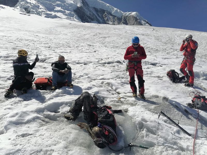 © Reuters. Peruvian mountain police and mountain rescue workers gather around the remains of American climber William Stampfl who went missing in 2002 and is suspected to have died in an avalanche, in Huascaran, in this undated handout picture received by Reuters July 9, 2024.  Policia Nacional del Peru (PNP)/Handout via REUTERS