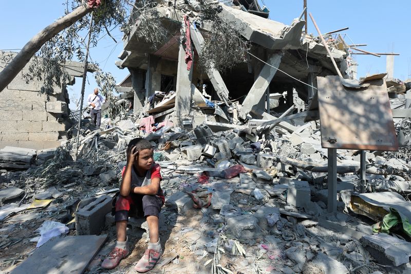 © Reuters. A child sits amid the rubble as Palestinians inspect a house destroyed in an Israeli strike, amid the Israel-Hamas conflict, in Nusairat refuge camp, in the central Gaza Strip, July 9, 2024. REUTERS/Ramadan Abed     