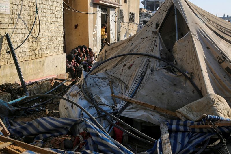 © Reuters. Palestinians sit near a damaged tent at the site of an Israeli strike near a school sheltering displaced people, amid Israel-Hamas conflict, in Khan Younis in the southern Gaza Strip July 10, 2024. REUTERS/Hatem Khaled