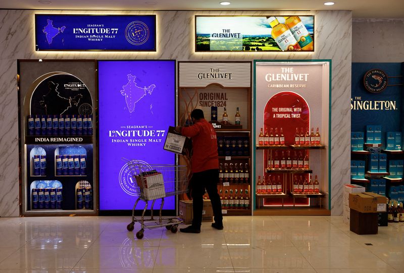 © Reuters. FILE PHOTO: A salesman stores whisky bottles for sale at a liquor store in Gurugram, India, December 11, 2023. REUTERS/Sahiba Chawdhary/File Photo