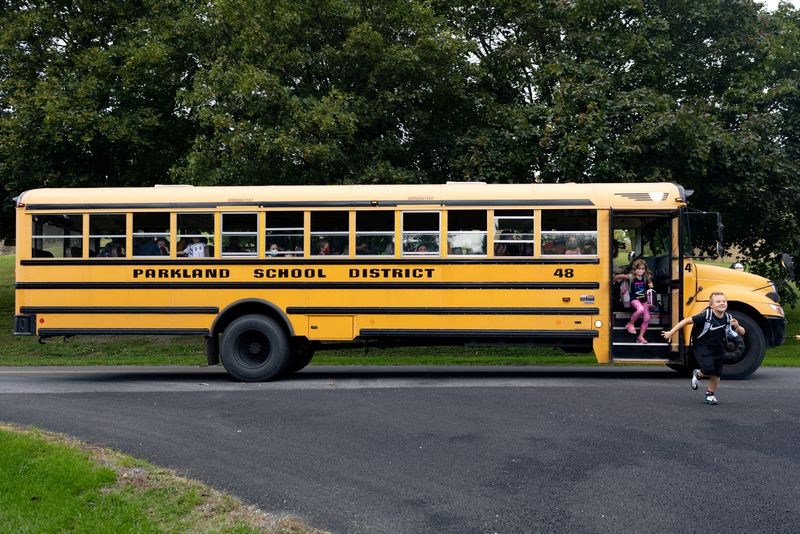 © Reuters. FILE PHOTO: Alex Toth, 7, runs off the bus to his mother, Kelly Toth (not pictured), after school in Schnecksville, Pennsylvania, U.S. September 22, 2021. Picture taken September 22, 2021. REUTERS/Hannah Beier/File Photo