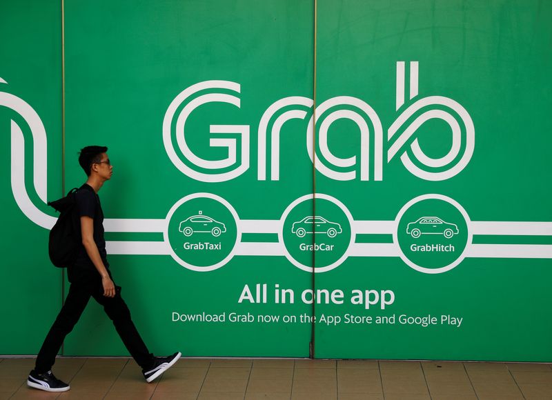 &copy; Reuters. FILE PHOTO: A man walks past a Grab office in Singapore March 26, 2018. REUTERS/Edgar Su/File Photo