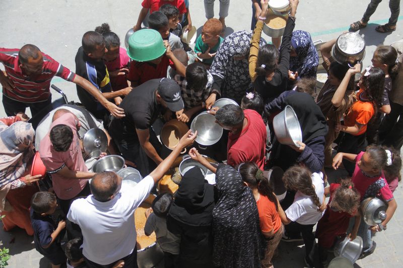 &copy; Reuters. FILE PHOTO: Palestinians gather to receive food cooked by a charity kitchen, as they struggle with food scarcity, basic necessities amid the conflict between Israel and Hamas continues, in Jabalia refugee camp, in the northern Gaza Strip, June 19, 2024. R