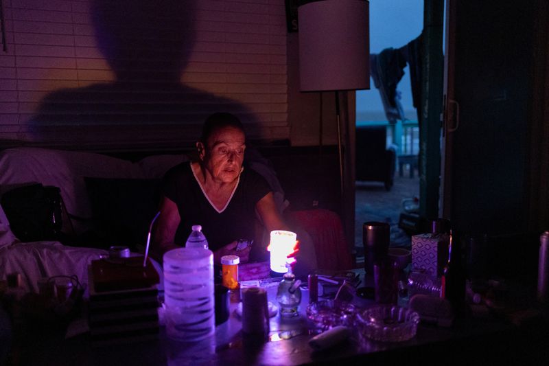 © Reuters. FILE PHOTO: Marguerite Thomas lights candles at dusk after losing electricity due to Hurricane Beryl in Surfside Beach, Texas, U.S., July 9, 2024.  REUTERS/Adrees Latif/File Photo