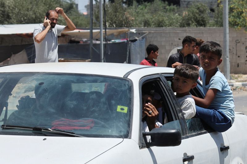 © Reuters. Displaced Palestinian children, who fled north Gaza after they were ordered by Israeli army to move southward, amid Israel-Hamas conflict, travel in a car as they arrive in Nuseirat in the central Gaza Strip, July 11, 2024. REUTERS/Ramadan Abed 