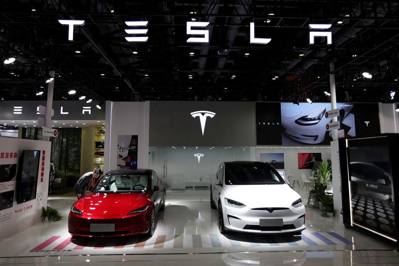 © Reuters. ẢNH TẬP TIN: Một nhân viên đang xem mẫu xe sedan Model 3 mới của Tesla được trưng bày bên cạnh mẫu SUV Model X tại Hội chợ Thương mại Dịch vụ Quốc tế Trung Quốc (CIFTIS) ở Bắc Kinh, Trung Quốc, ngày 2 tháng 9 năm 2023. REUTERS/Florence Lo/Ảnh tập tin