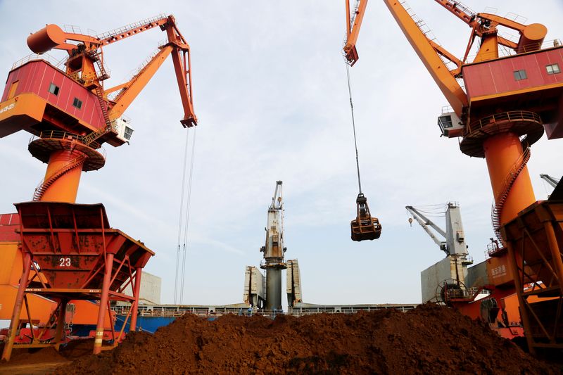 &copy; Reuters. FILE PHOTO: Cranes unload imported iron ore from a cargo vessel at a port in Lianyungang, Jiangsu province, China October 27, 2019. REUTERS/Stringer/File Photo
