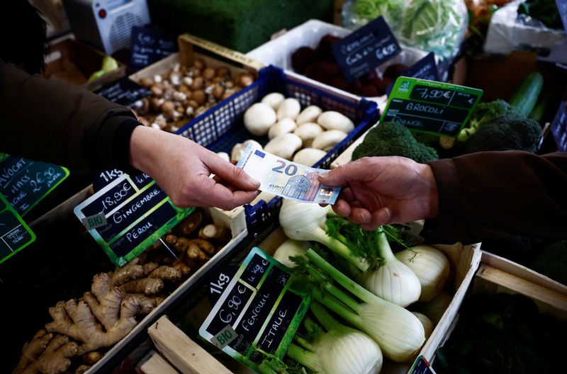 &copy; Reuters. Un cliente paga con una banconota da venti euro in un mercato locale di Nantes, Francia, 1 febbraio 2024. REUTERS/Stephane Mahe/Foto d'archivio