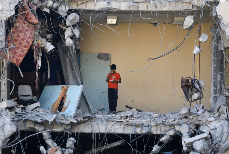 © رويترز.  صبي فلسطيني يقف بين الأنقاض، بعد انسحاب القوات الإسرائيلية من جزء من مدينة غزة، في أعقاب عملية برية، وسط الصراع بين إسرائيل وحماس، في مدينة غزة، 12 يوليو، 2024. رويترز / داود أبو الكاس