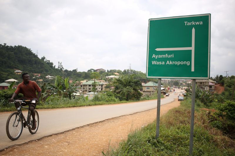 &copy; Reuters. Um homem passa de bicicleta por uma placa de trânsito que mostra Tarkwa, no caminho de Prestea, uma cidade mineira no sudoeste de Ganan26/07/2019nREUTERS/Siphiwe Sibekon