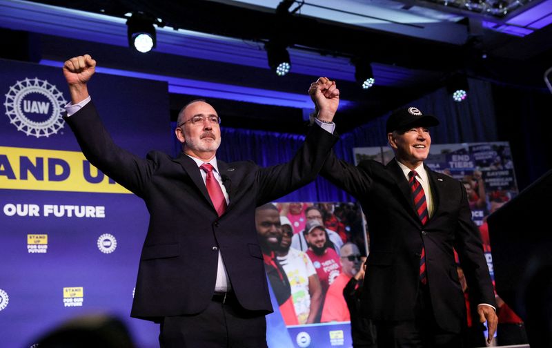 &copy; Reuters. FILE PHOTO: U.S. President Joe Biden holds hands with United Auto Workers (UAW) President Shawn Fain after Fain and the UAW endorsed Biden for president prior to Biden's remarks at their Community Action Program (CAP) legislative conference in Washington,