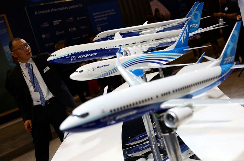 &copy; Reuters. FILE PHOTO: A man passes Boeing model planes on display at the Singapore Airshow at Changi Exhibition Centre in Singapore February 20, 2024. REUTERS/Edgar Su/File Photo