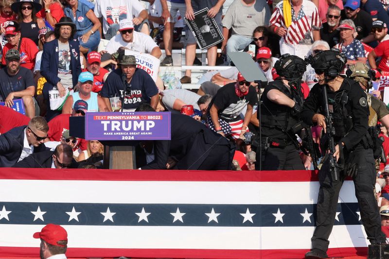 &copy; Reuters. Republican presidential candidate and former U.S. President Donald Trump is assisted by U.S. Secret Service personnel after gunfire rang out during a campaign rally at the Butler Farm Show in Butler, Pennsylvania, U.S., July 13, 2024. REUTERS/Brendan McDe