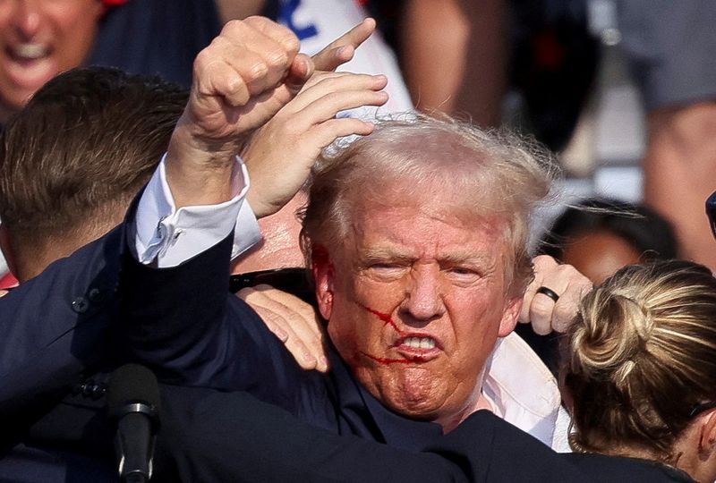 © Reuters. FILE PHOTO: Republican presidential candidate and former U.S. President Donald Trump is assisted by the Secret Service after gunfire rang out during a campaign rally at the Butler Farm Show in Butler, Pennsylvania, U.S., July 13, 2024. REUTERS/Brendan McDermid/File Photo