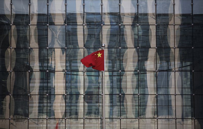 &copy; Reuters. FILE PHOTO: A Chinese national flag flutters at the headquarters of a commercial bank on a financial street near the headquarters of the People's Bank of China, China's central bank, in central Beijing November 24, 2014.nREUTERS/Kim Kyung-Hoon/File Photo