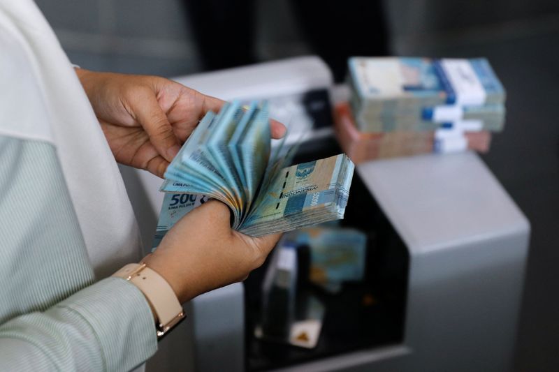 &copy; Reuters. FILE PHOTO: A teller counts Indonesian rupiah bank notes at a money changer in Jakarta, Indonesia, October 14, 2022. REUTERS/Willy Kurniawan/File Photo