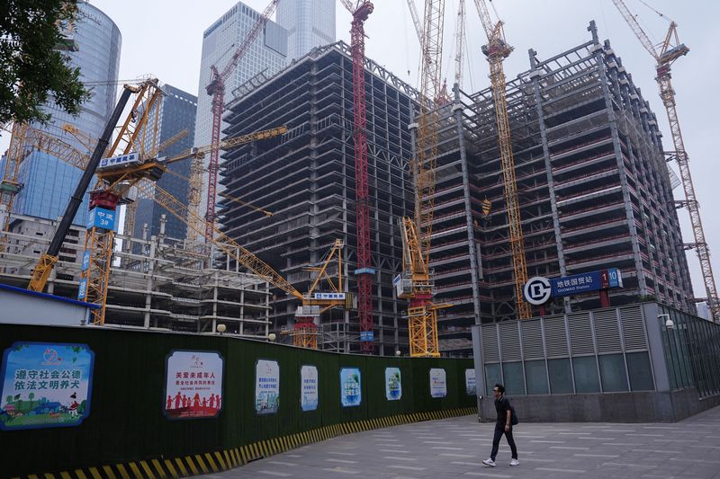 &copy; Reuters. FILE PHOTO: A person walks past a construction site in Beijing's Central Business District (CBD), China July 14, 2024. REUTERS/Tingshu Wang/File photo