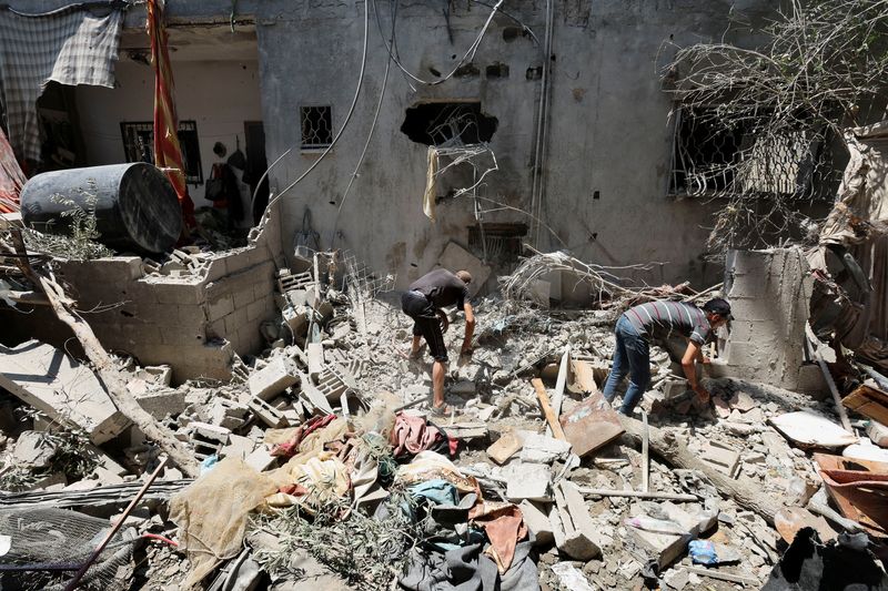 © Reuters. Palestinians inspect a house hit in an Israeli strike, amid the Israel-Hamas conflict, in Deir Al-Balah in the central Gaza Strip, July 15, 2024. REUTERS/Ramadan Abed