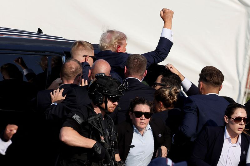 © Reuters. FILE PHOTO: Republican presidential candidate and former U.S. President Donald Trump gestures as he gets into a vehicle with the assistance of U.S. Secret Service personnel after he was shot in the right ear during a campaign rally at the Butler Farm Show in Butler, Pennsylvania, U.S., July 13, 2024. REUTERS/Brendan McDermid/File Photo