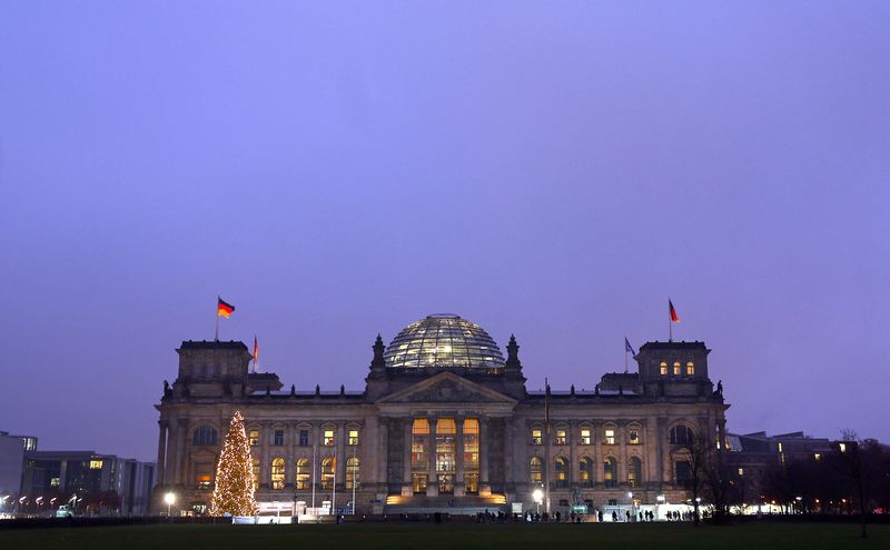 &copy; Reuters. Bandiere nazionali tedesche sventolano in cima all'edificio illuminato del Reichstag, sede del Bundestag, a Berlino, Germania, 9 dicembre 2022. REUTERS/Lisi Niesner/Foto d'archivion