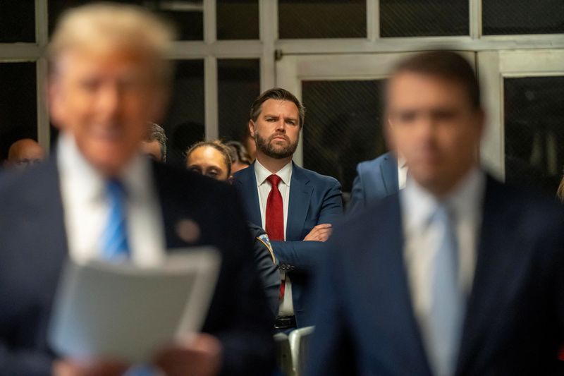 © Reuters. FILE PHOTO: US Senator JD Vance listens to former President Donald Trump address the Pool Press outside the  Manhattan Criminal Court room during trial in NYC May 13 2024. Mark Peterson/Pool via REUTERS/File Photo