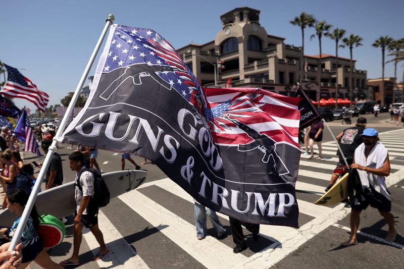 &copy; Reuters. FILE PHOTO: A pro-Trump supporter waves a flag reading God Guns and Trump during a demonstration in support of former U.S. President Donald Trump who was shot the previous day in an assassination attempt during a rally in Pennsylvania, in Huntington Beach