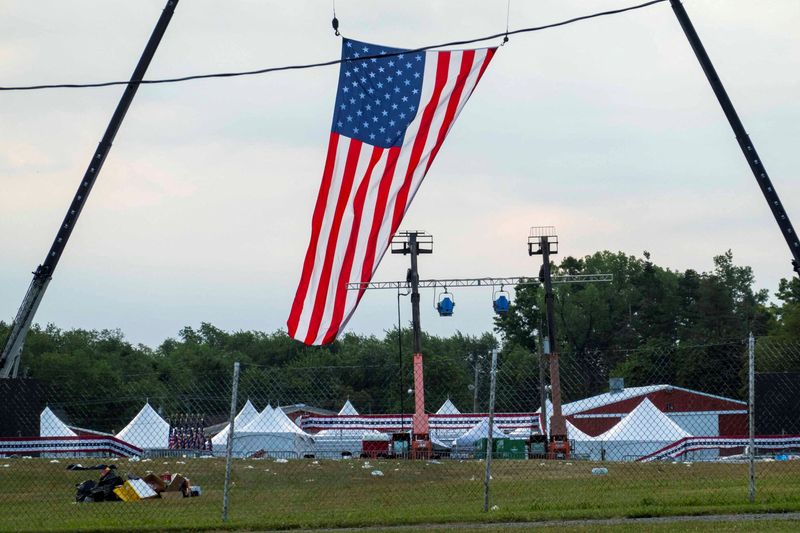 © Reuters. FILE PHOTO: A flag hung over the stage waves in the wind at the event grounds where the rally was held, during the law enforcement investigation into gunfire at a campaign rally of Republican presidential candidate and former U.S. President Donald Trump in Butler, Pennsylvania, U.S. July 15, 2024. REUTERS/Carlos Osorio     