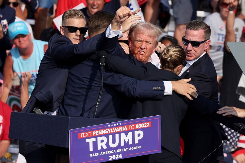 &copy; Reuters. Republican presidential candidate and former U.S. President Donald Trump gestures with a bloodied face while he is assisted by U.S. Secret Service personnel after he was shot in the right ear during a campaign rally at the Butler Farm Show in Butler, Penn