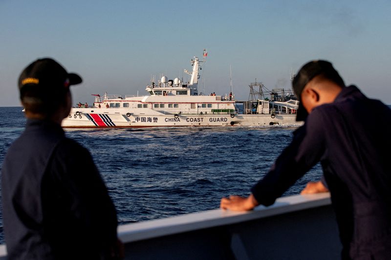 © Reuters. Members of the Philippine Coast Guard stand alert as a Chinese Coast Guard vessel blocks their way to a resupply mission at Second Thomas Shoal in the South China Sea, March 5, 2024. REUTERS/Adrian Portugal/File Photo