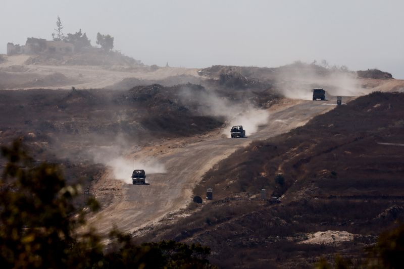 © Reuters. Military vehicles manoeuvre inside Gaza, amid the Israel-Hamas conflict, as seen from Israel, July 16, 2024. REUTERS/Amir Cohen 