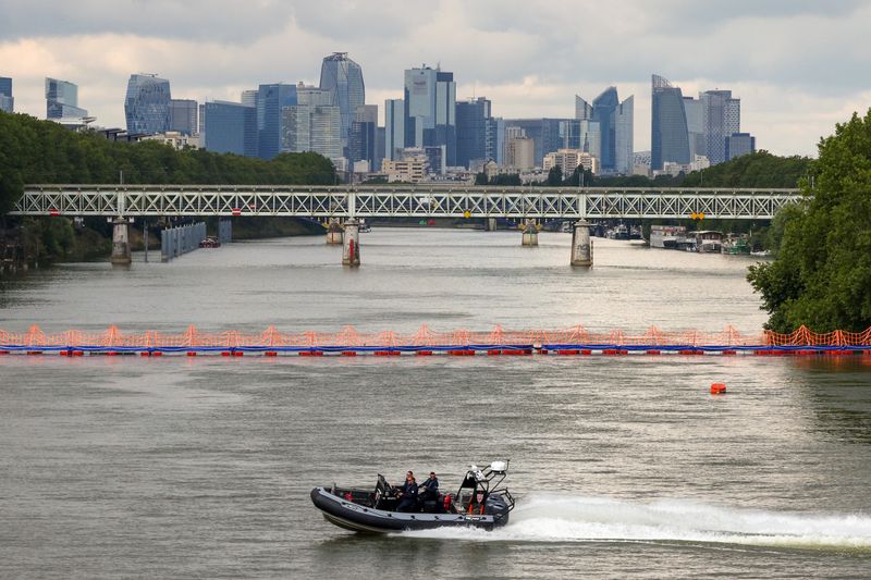 &copy; Reuters. FILE PHOTO: A CRS police speedboat patrols on the River Seine near a floating barrier with the business district of La Defence seen in the distance, ahead of the Paris 2024 Olympics and Paralymics Games in Paris, France, July 13, 2024.  REUTERS/Kevin Coom