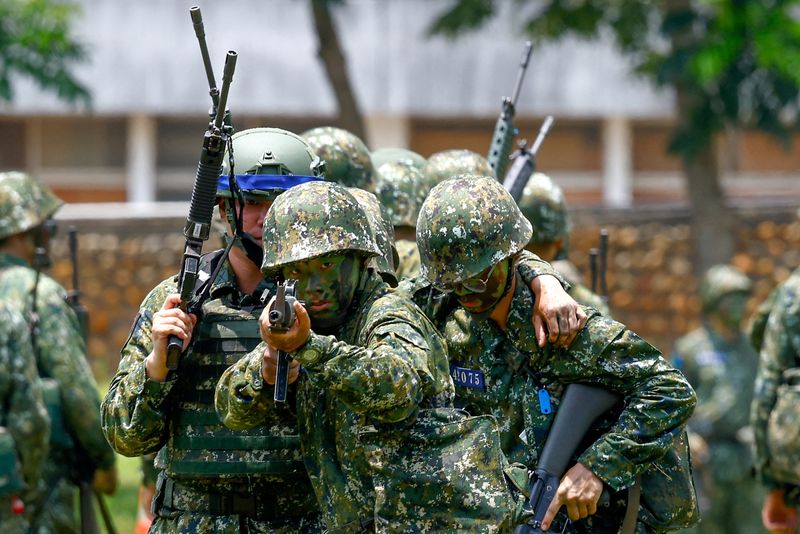 © Reuters. FILE PHOTO: A new military recruit aims a weapon during a training in Taichung, Taiwan June 28, 2024. REUTERS/Ann Wang/File Photo