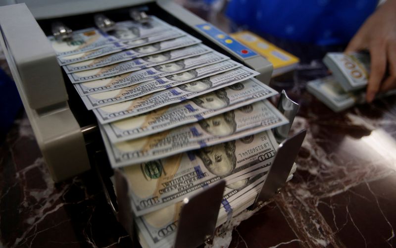 &copy; Reuters. FILE PHOTO: An employee of a bank counts US dollar notes. REUTERS/Kham/File Photo