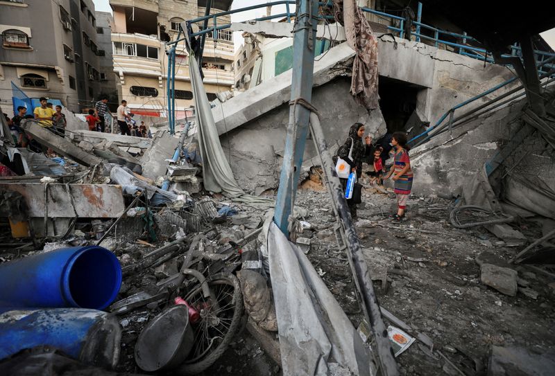 © Reuters. Palestinians stand amid debris at a U.N.-run school sheltering displaced people, following an Israeli strike, amid Israel-Hamas conflict, in Gaza City, July 18, 2024. REUTERS/Dawoud Abu Alkas    