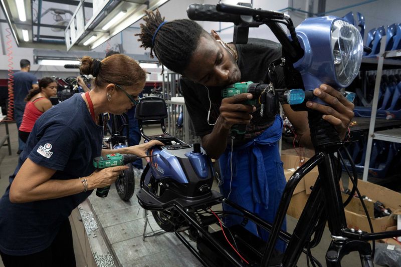 &copy; Reuters. Trabalhadores montam uma scooter na fábrica da Vedca em Havanan15/07/2024nREUTERS/Alexandre Meneghini