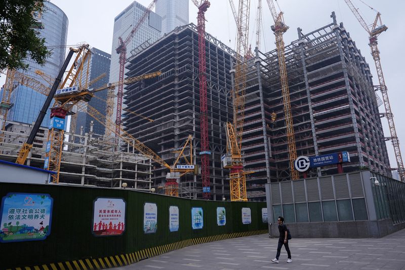 &copy; Reuters. FILE PHOTO: A person walks past a construction site in Beijing's Central Business District (CBD), China July 14, 2024. REUTERS/Tingshu Wang/File Photo