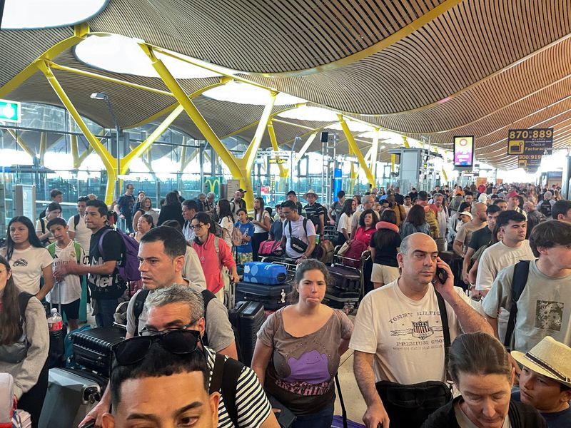 &copy; Reuters. Passengers wait at Barajas Airport, as Spanish airport operator Aena on Friday reported a computer systems "incident" at all Spanish airports which may cause flight delays, in Madrid, Spain July 19, 2024. REUTERS/Elena Rodriguez