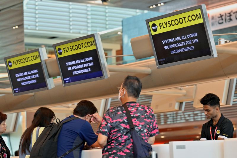 © Reuters. Scoot passengers wait to be checked-in manually at Changi Airport Terminal 1 in Singapore after a global IT system outage, July 19, 2024. REUTERS/Caroline Chia