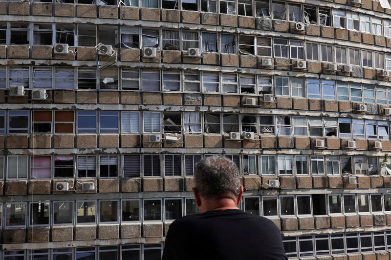 &copy; Reuters. Un uomo osserva un edificio danneggiato sul luogo di un'esplosione, durante il conflitto tra Israele e Hamas a Tel Aviv, in Israele, il 19 luglio 2024. REUTERS/Ricardo Moraes