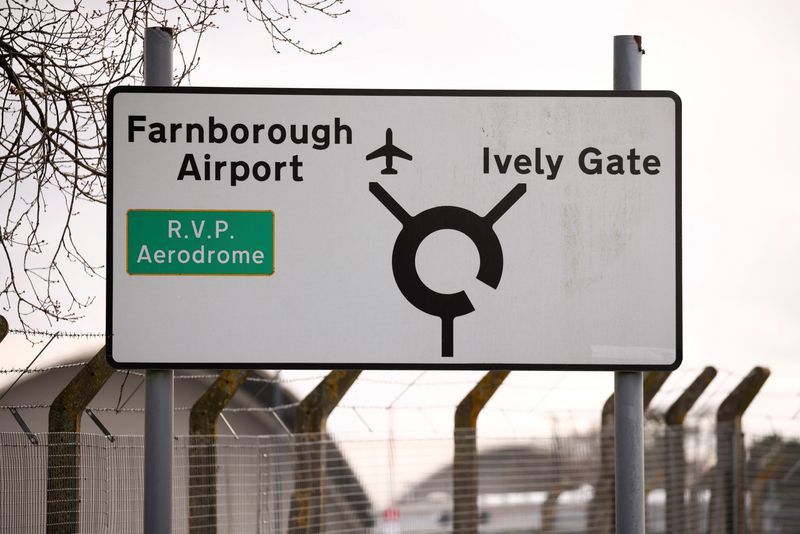 &copy; Reuters. FILE PHOTO: Signage is pictured next to a fence of the Farnborough Airport, in Farnborough, Britain March 9, 2022. REUTERS/Henry Nicholls/File Photo