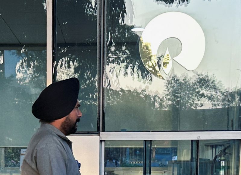 &copy; Reuters. FILE PHOTO: A guard walks past the Reliance Industries logo near the entrance of Dhirubhai Ambani Knowledge City in Navi Mumbai, March 15, 2024. REUTERS/Francis Mascarenhas/File Photo