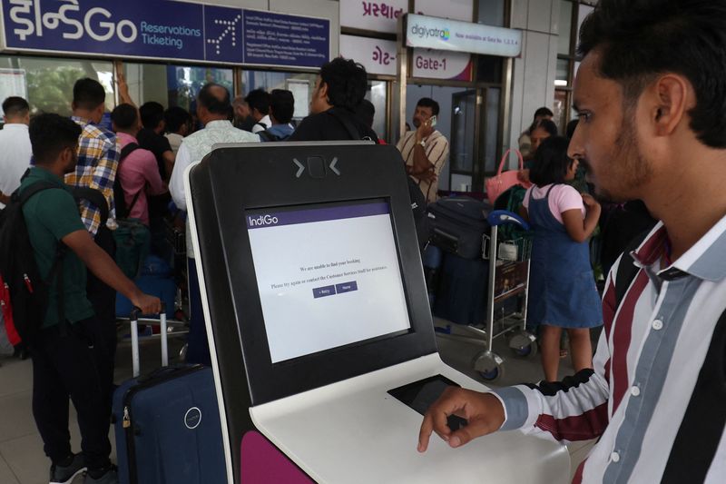 © Reuters. A passenger reads a message after he tried to use a self-check-in kiosk at a departure area at Sardar Vallabhbhai Patel International Airport following a global IT outage, in Ahmedabad, India, July 19, 2024. REUTERS/Amit Dave