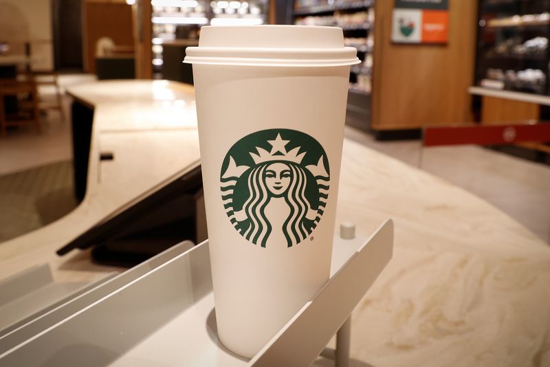 © Reuters. FILE PHOTO: Starbucks beverage cups are displayed where customers will receive their orders at a new Starbucks store, its first-ever in partnership with Amazon Go that lets customers check out without a cashier, during a preview of the store which opens on November 18, 2021, on Manhattan's East side in New York City, New York, U.S., November 16, 2021. REUTERS/Mike Segar/File Photo