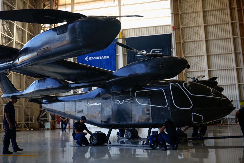 &copy; Reuters. Employees work near the full-scale prototype of an electric vertical take-off and landing (eVTOL) aircraft developed by Eve Air Mobility, an Embraer group company, as it is presented for the first time in Gaviao Peixoto, Brazil July 3, 2024. REUTERS/Amand